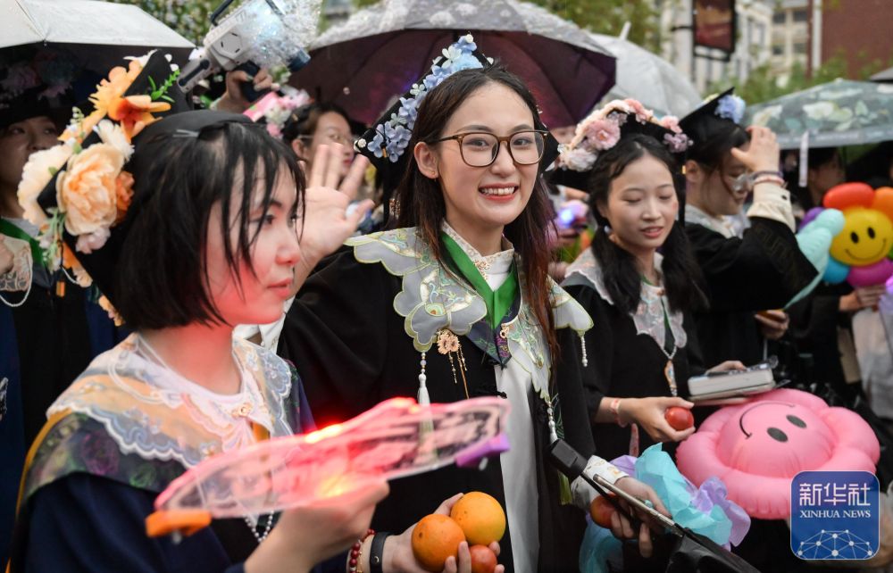 6月21日,华中农业大学学生在校园里冒雨巡游。